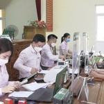 Cán bộ NHCSXH huyện Thường Xuân giải ngân vốn vay cho người dân tại Điểm giao dịch xã
