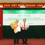 Tổng Giám đốc Dương Quyết Thắng (bên phải) trao Quyết định và tặng hoa chúc mừng Giám đốc chi nhánh NHCSXH thành phố Hà Nội Phạm Văn Quyết