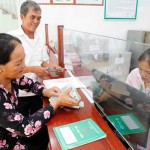 Vợ chồng ông Hoàng Hữu Hiện rất vui khi đến NHCSXH huyện Lệ Thủy nhận 100 triệu đồng vốn vay để đầu tư nuôi lợn rừng, lợn nái