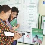 Cán bộ NHCSXH huyện Bình Sơn hướng dẫn khách hàng cài đặt ứng dụng VBSP Smart Banking