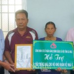Giám đốc NHCSXH huyện Ðầm Dơi Mai Quốc Dương (ngoài cùng bìa phải) trao biển hỗ trợ nhà cho ông Diệp Văn Minh