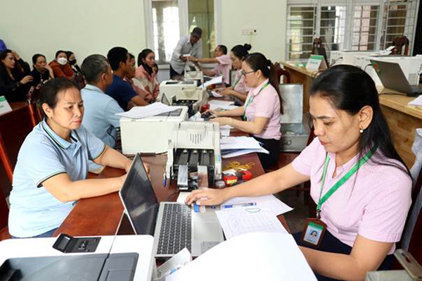 Các cán bộ NHCSXH huyện Lắk giải ngân vốn vay ưu đãi cho người dân tại Điểm giao dịch xã