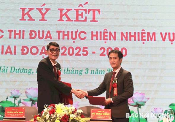 Đại diện chi nhánh NHCSXH tỉnh và Công đoàn ký giao ước thi đua
