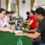 Cán bộ tín dụng Phòng giao dịch NHCSXH Phú Hòa hướng dẫn hộ vay hoàn tất thủ tục nhận vốn tại điểm giao dịch Hòa Quang Nam, xã Phú Hòa 2