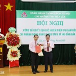 Phó Tổng Giám đốc Huỳnh Văn Thuận trao Quyết định của Tổng Giám đốc NHCSXH và tặng hoa chúc mừng Giám đốc chi nhánh NHCSXH tỉnh Đắk Lắk Đào Thái Hòa