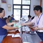 Cán bộ Phòng giao dịch NHCSXH Yên Bình giải ngân vốn cho các đối tượng chính sách tại thôn Hương Lý, xã Yên Bình