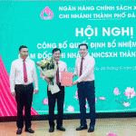 Phó Tổng Giám đốc NHCSXH Đoàn Trung Thành (ngoài cùng bên phải) và Phó Chủ tịch Thường trực UBND TP Đà Nẵng Hồ Kỳ Minh (ngoài cùng bên trái) trao hoa và Quyết định bổ nhiệm ổng Đoàn Ngọc Chung - Giám đốc chi nhánh NHCSXH TP Đà Nẵng