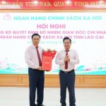 Phó Tổng Giám đốc NHCSXH Huỳnh Văn Thuận (bên phải) trao Quyết định và chúc mừng Giám đốc chi nhánh Trần Quang Sơn