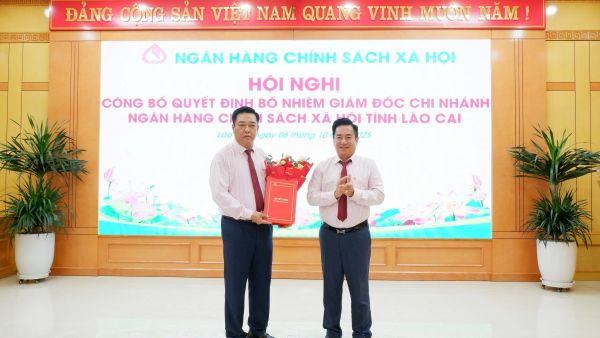 Phó Tổng Giám đốc NHCSXH Huỳnh Văn Thuận (bên phải) trao Quyết định và chúc mừng Giám đốc chi nhánh Trần Quang Sơn
