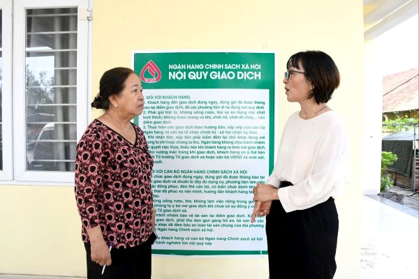 Bà Nguyễn Thị Hạnh (bên phải) trao đổi với bà Huỳnh Thị Thu về triển khai ủy thác tín dụng chính sách trên địa bàn phường Tam Kỳ