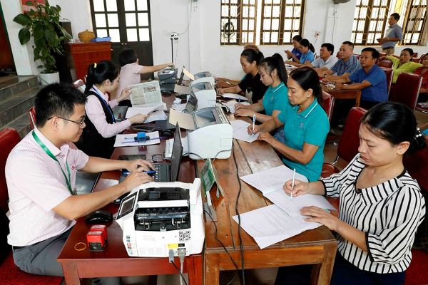 Phòng giao dịch NHCSXH Quỳnh Lưu giao dịch với bà con tại điểm giao dịch