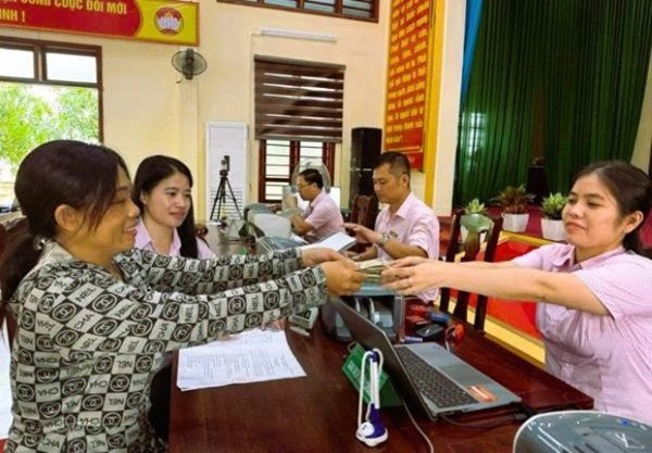 Phòng giao dịch NHCSXH Nghi Lộc giải ngân vốn ưu đãi từ chương trình cho vay học ngành STEM cho hộ gia đình bà Vũ Kiều Anh (ngoài cùng bên trái) ở xóm Kim Ngọc, xã Trung Lộc