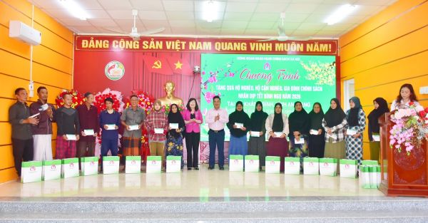 Phó Tổng Giám đốc NHCSXH Huỳnh Văn Thuận (áo trắng đứng giữa) trao tặng quà cho người dân xã Khánh Bình (An Giang)