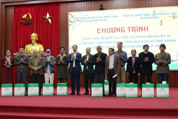 Giám đốc chi nhánh NHCSXH thành phố Hà Nội Phạm Văn Quyết cùng Lãnh đạo địa phương trao tặng quà Tết cho các hộ gia đình có công với Cách mạng và hộ có hoàn cảnh khó khăn ở xã Phú Xuyên