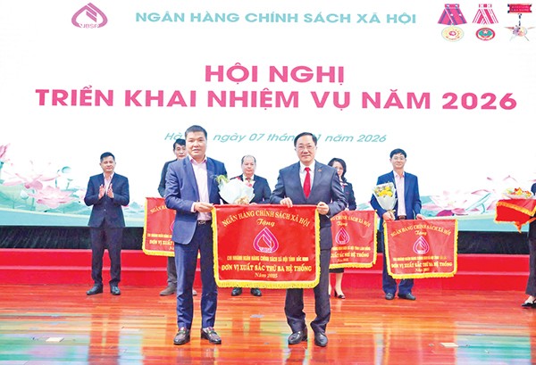 Năm 2025, chi nhánh tỉnh Bắc Ninh vinh dự được nhận danh hiệu đơn vị xuất sắc thứ Ba hệ thống NHCSXH (Trong ảnh: Tổng Giám đốc NHCSXH Dương Quyết Thắng (bên phải) trao tặng Cờ cho Giám đốc chi nhánh NHCSXH tỉnh Bắc Ninh Đỗ Văn Hiện)