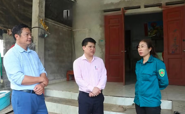 Cán bộ xã Yên Trạch và NHCSXH trao đổi với chị Đặng Minh Huệ